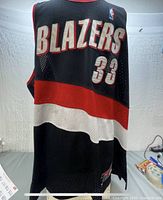 Front side of the black mesh vintage Champion jersey with 'BLAZERS' and number 33 in white and red trim, showing the color block design and Champion logo patch.