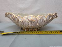 Side view of the vintage Haeger pottery vase showing the gold tweed leaf exterior and scalloped rim, with a measuring tape indicating about 29 cm length.