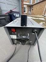 Top view of the Weldmate 75 stick welder showing brand name and model, control panel with knob and cables connected.