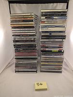 Photo showing full stacks of 56 rock CD jewel cases including artists Bon Jovi, Led Zeppelin, Pink Floyd, Aerosmith, AC/DC, and more.