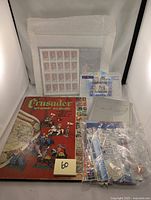 Lot showing Crusaders Stamp Album, loose stamps in baggies, and various stamp sheets in protective sleeves