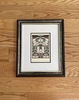 Framed Native art print with Black Bear Box Design by Carl Stromquist on wooden floor.