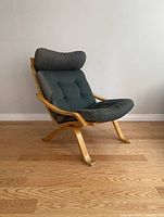 Angled front right view of chair showing frame, cushion, headrest