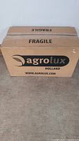 Boxed Agrolux grow light fixture with fragile labeling and branding visible.