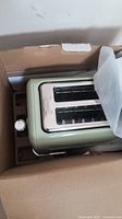Buydeem DT620 toaster in original box showing side view with control knob