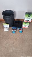 Photo showing stacked 3-gallon black soft pots, small starter pots, fertilizer boxes, Soil Moist granules and starter tray.