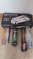 Photo showing the Neutron 2100 reflector box and four grow light bulbs with their original packaging.