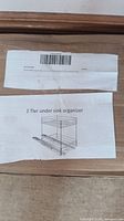 Photo of label on box showing 2-tier under sink organizer with sliding wire drawers