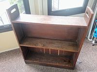 Front and side view showing three shelves, hardwood construction, and integrated side handles with inlay detail.