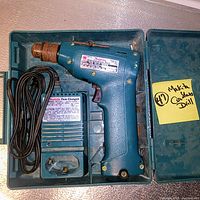 Top-down view of Makita cordless drill, charger and molded case interior
