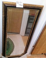 Front view of the rectangular mirror showing the full frame and reflective surface angled upright against a wall