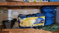 Wide view of all items together including tent bag, gloves, sleeping bags, basket, and tarps