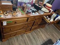 Full view of the wood dresser with seven drawers, some open showing dovetail drawer construction, contents on top and inside excluded.