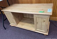 Front angle showing top surface, left and right storage compartments with paneled doors, and open shelf in the middle.