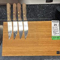 Henckels wooden magnetic board holding four steak knives with wooden handles