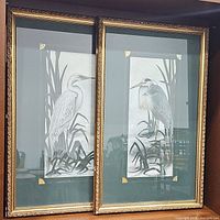 Photo of two framed bird prints featuring herons by Dianne Krumel with gold-accented green mats and ornate gold frames