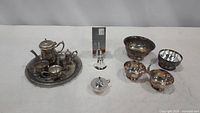 Lot overview showing all items: teapot set with tray, tea bell, oil lamp, three serving bowls