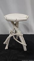 Front view of the white painted tree branch stool showing branch legs and octagonal seat.