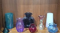 All seven vases arranged side by side showing variety in colors and shapes.