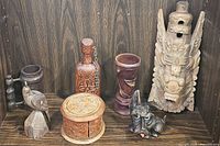 Full lot view showing all seven wooden carved items against a wood grain backdrop
