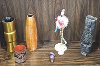 Full lot with all items displayed on wooden shelf showing variety of decorative pieces including vases, statues, and small cup.