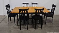 Full dining set including wooden rectangular table and six black slatted back chairs