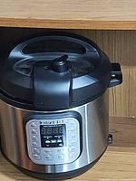 Front view of the Instant Pot showing display and control buttons including start and timer.