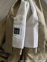 Close-up photo showing the label on the lining indicating 'inVU Drapery Company, Made in Canada', with custom length tag visible, and the gold dupioni silk outer fabric edge.