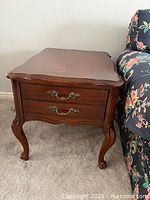 Side angle view of the hardwood Queen Anne style end table showing the drawer handles and leg details