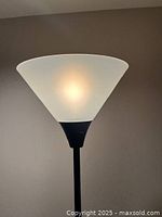 Close-up photo of the white plastic conical lampshade showing details and light diffusion.