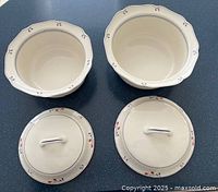 Two cream-colored Noritake casserole dishes with lids and scalloped edges decorated in Copper Bud pattern in red and blue.