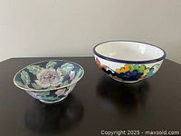 Two bowls displayed on a black surface: one Portuguese pottery bowl with green floral design and one colorful Italian decorative bowl.