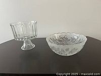 Two glass bowls on black surface: the scalloped etched rose dessert bowl and a clear glass pedestal bowl