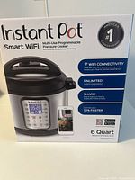 Front of the box showing the product name, WiFi connectivity features, and capacity of 6 quarts in brushed stainless steel.