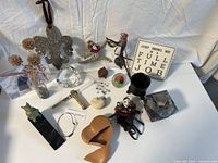 Overview of small assorted decorative items including fleur-de-lis ornament, framed photo, figurines, paperweight, and other décor pieces.