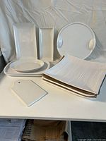 White ceramic serving trays and plates arranged on table showing various sizes and shapes.