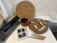 Photo showing all items including Chicago Cutlery carving set box, bamboo cutting board, woven wooden tray with cheese utensils, wooden bowl, cheese knives, and packaged cheese slicer.