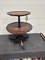 Full view of the two tier mahogany pie crust edge table on tripod base