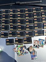 Photo of 39 shrink-wrapped sets of black 1991 Topps Stadium Club Members Only Limited Edition baseball card sets arranged in rows with one opened set and loose cards on surface.