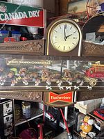 Overall view of woodgrain case, carved leaf accents and round analog clock face