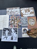 Overview photo showing all items including two 16x20 photos, baseball glove, memorabilia folder, advertisement, paperwork, and signed print
