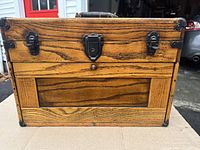 Front view of the vintage oak machinist toolbox showing wood grain, metal clasps, and metal corner protectors.