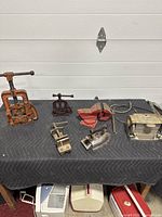 Full lot of antique vices, grinding tool, electric iron showed together on table