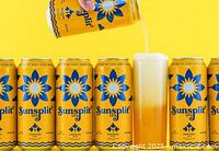 Yellow Sunsplit IPA cans arranged in row and one being poured into a glass