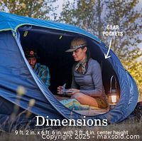 Open tent pitched outdoors showing interior with gear pockets and branding