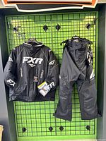 FXR Octane jacket and FXR Clutch FX pants hung on grid display