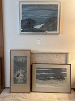 Three framed artworks displayed together against wall.