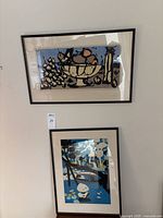 Two framed prints hung on wall, top and bottom.