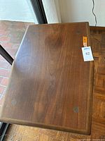 Top view of walnut veneer surface showing overall grain and small circular felt pads.