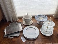 Overview of entire lot showing all serving items arranged on wooden floor near window.